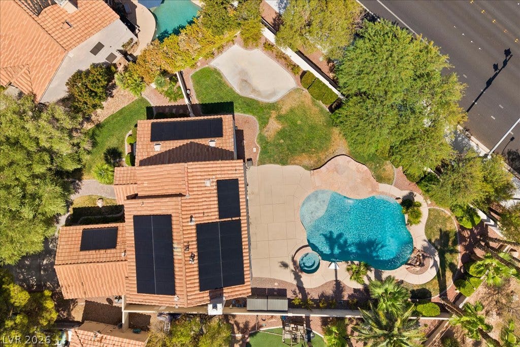 2000 Silverton Drive, Henderson, NV 89074 An aerial perspective showcases a home with solar panels, a sparkling swimming pool, and an inviting backyard.