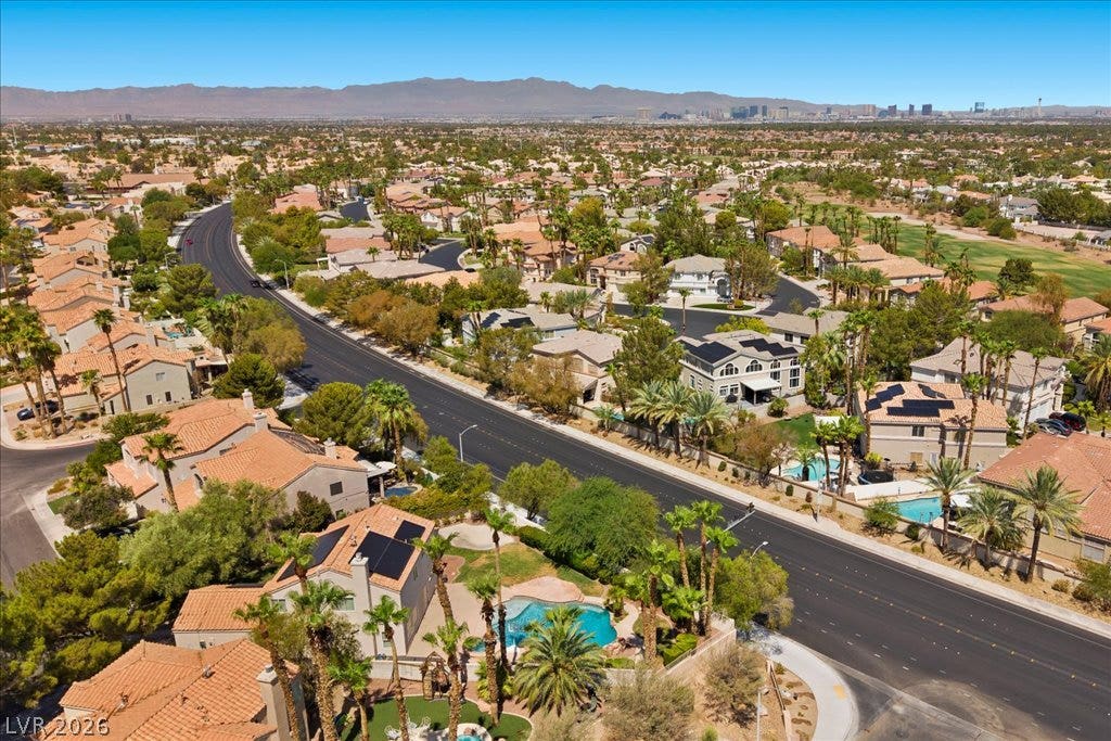 2000 Silverton Drive, Henderson, NV 89074 An aerial panorama reveals a vast suburban landscape with distant mountains, many properties featuring pools, and solar panels integrated into rooftops.