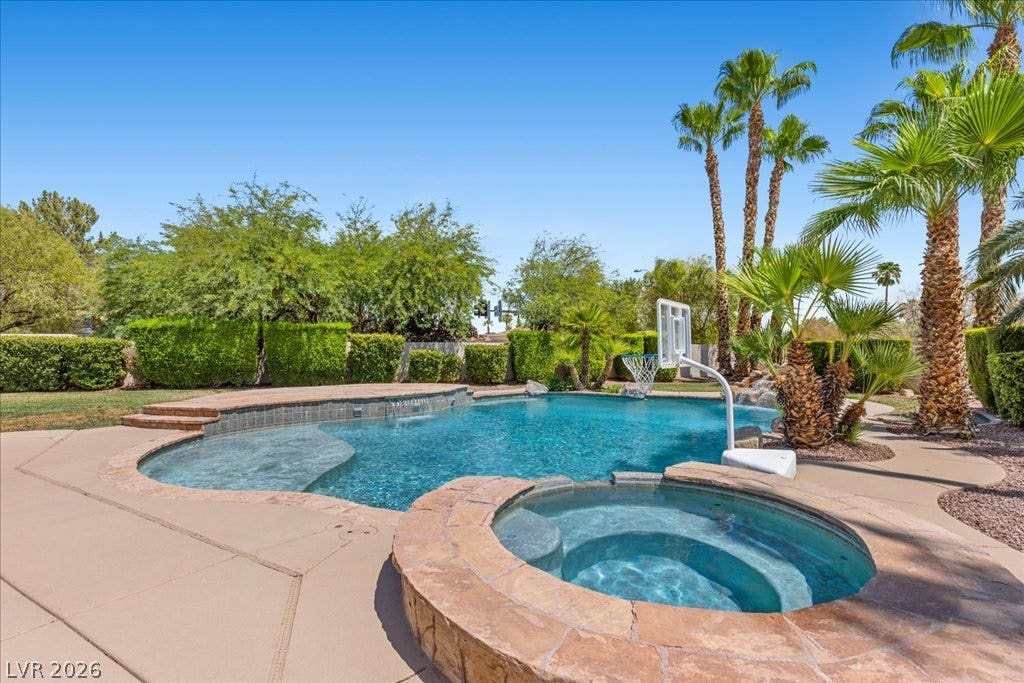 2000 Silverton Drive, Henderson, NV 89074 An inviting backyard oasis offers a sparkling pool with an integrated spa, set amidst lush tropical landscaping.