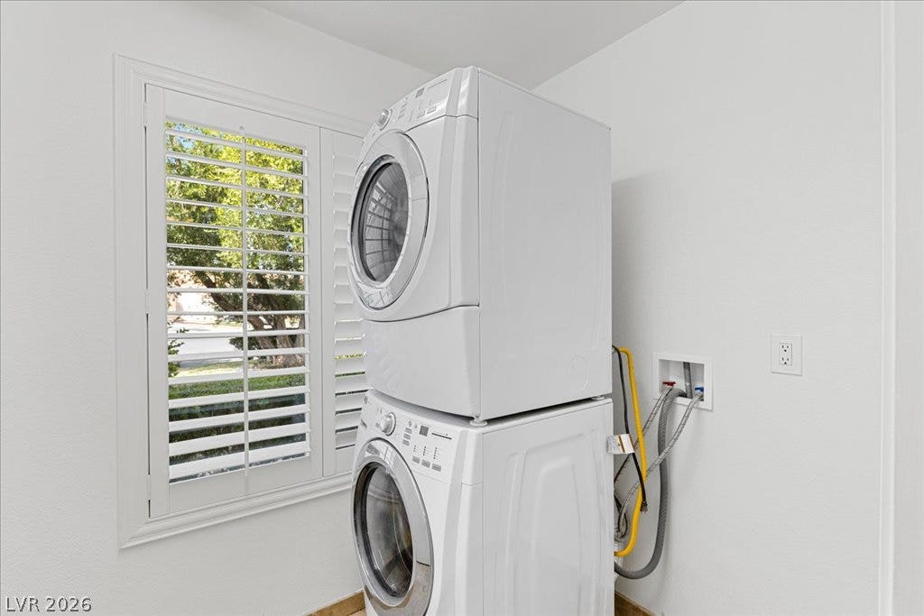 2000 Silverton Drive, Henderson, NV 89074 A dedicated laundry area features a stacked washer and dryer, optimizing space efficiency with a bright outdoor view.
