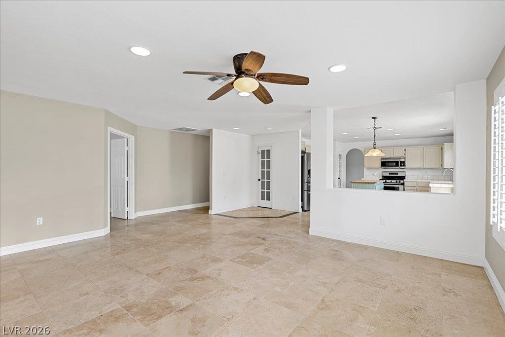 2000 Silverton Drive, Henderson, NV 89074 A spacious living area with tile flooring seamlessly connects to the kitchen, offering an open concept design.