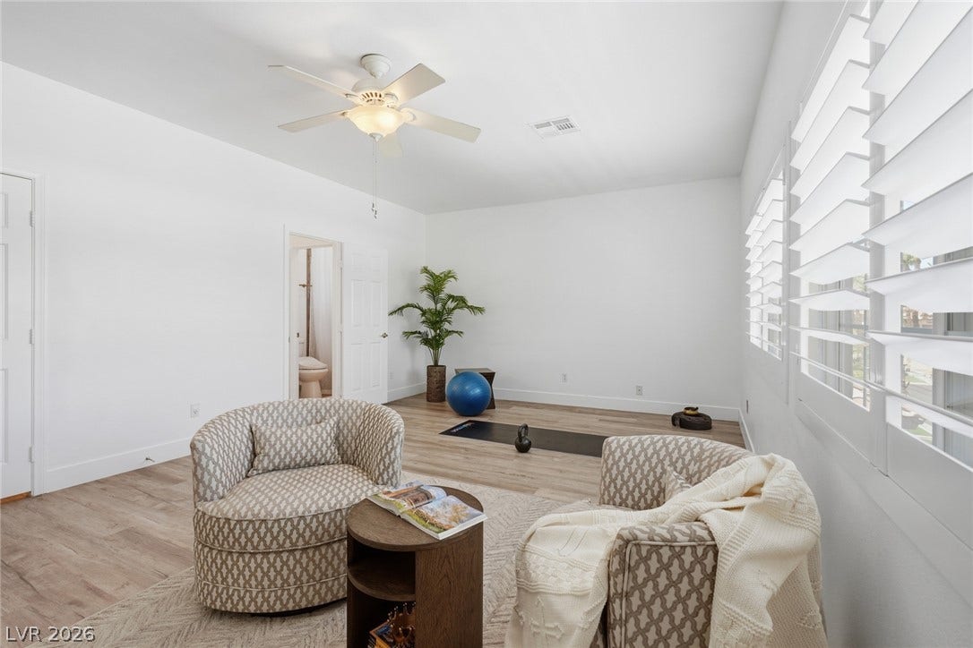 9615 Sedona Hills Court, Las Vegas, NV 89147 Well-lit room features plantation shutters, a ceiling fan, and durable wood flooring.