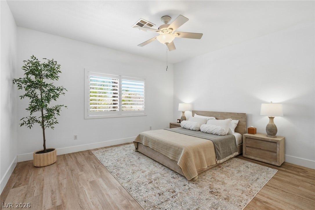 9615 Sedona Hills Court, Las Vegas, NV 89147 A well-lit bedroom features hardwood flooring and a stylish ceiling fan, creating a comfortable retreat.