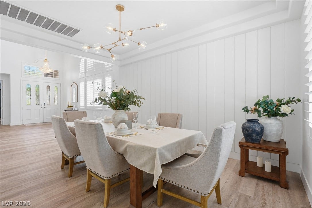 9615 Sedona Hills Court, Las Vegas, NV 89147 A radiant dining area, bathed in natural light, offers an inviting setting for gatherings with stylish fixtures and wood floors.
