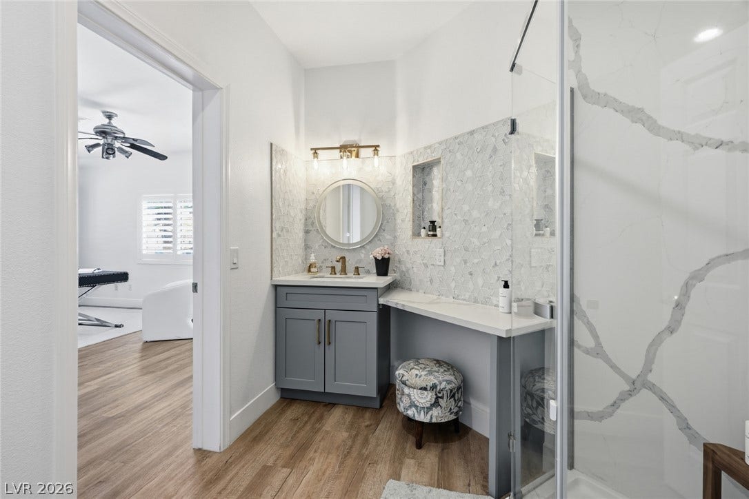 9615 Sedona Hills Court, Las Vegas, NV 89147 A well-appointed primary bathroom featuring a vanity with elegant finishes and a glass-enclosed shower.
