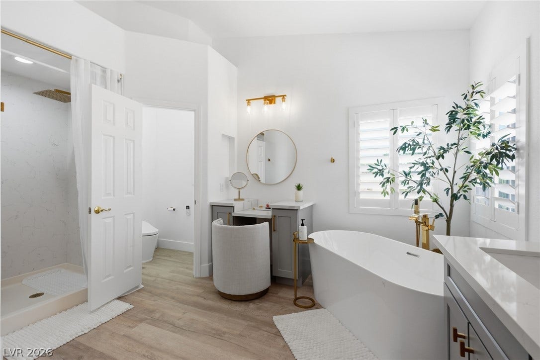 9615 Sedona Hills Court, Las Vegas, NV 89147 Indulge in this naturally illuminated primary bathroom featuring a freestanding tub and stylish vanity.