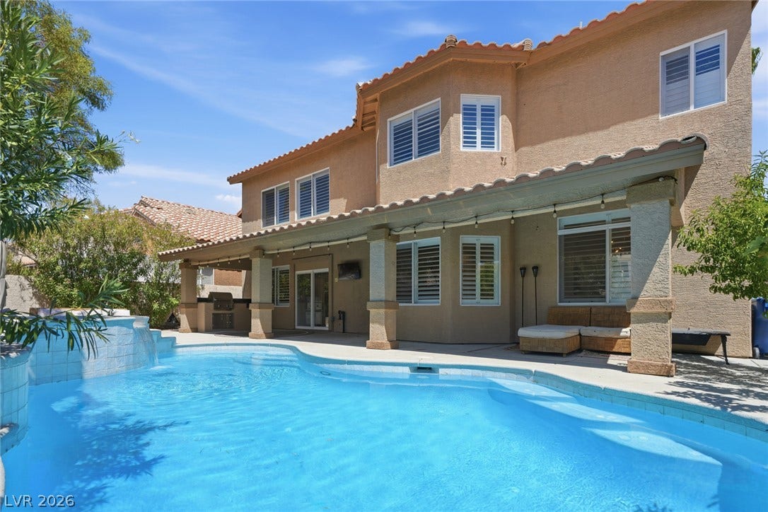 9615 Sedona Hills Court, Las Vegas, NV 89147 A refreshing pool with a tranquil waterfall feature complements a covered patio with an outdoor kitchen.