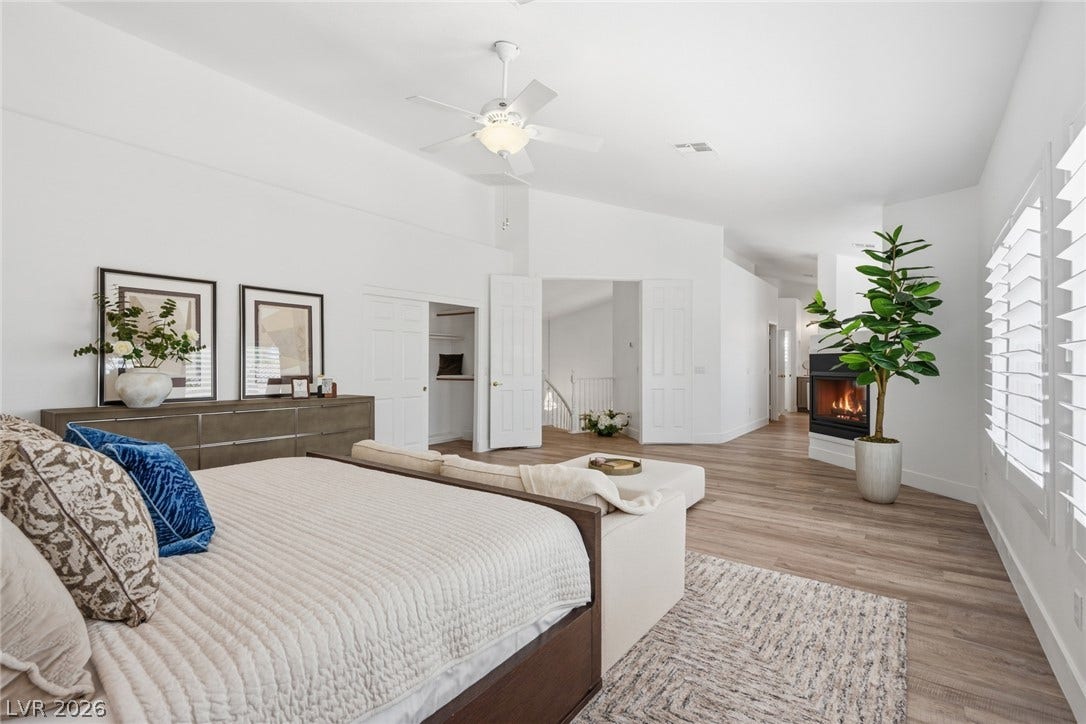 9615 Sedona Hills Court, Las Vegas, NV 89147 A spacious primary suite features a cozy corner fireplace, vaulted ceilings, and ample natural light.