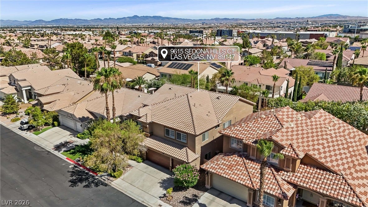 9615 Sedona Hills Court, Las Vegas, NV 89147 An aerial perspective reveals a well-maintained neighborhood with tile roofs, lush landscaping, and distant mountain vistas.