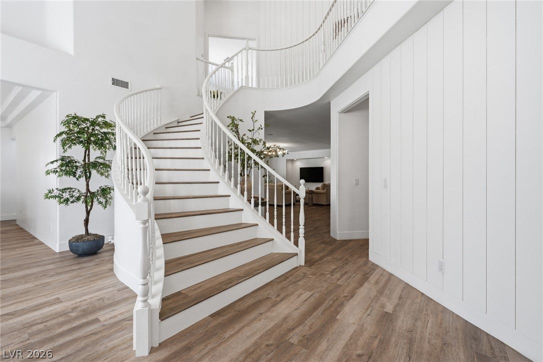 9615 Sedona Hills Court, Las Vegas, NV 89147 A grand curved staircase with natural wood treads elegantly anchors the luminous entryway.