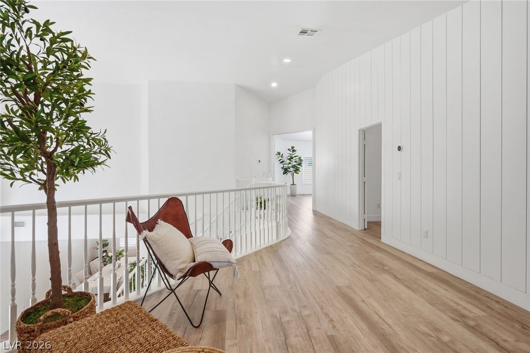 9615 Sedona Hills Court, Las Vegas, NV 89147 A well-lit second-story landing features light wood flooring and a modern white railing overlooking the living space below.