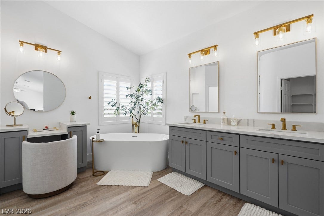 9615 Sedona Hills Court, Las Vegas, NV 89147 A freestanding tub and double vanity define this luminous bathroom, boasting light wood flooring.