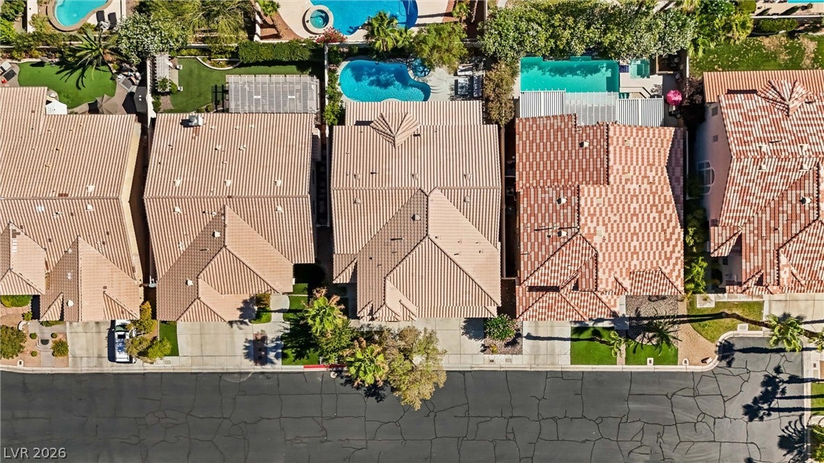 9615 Sedona Hills Court, Las Vegas, NV 89147 An aerial perspective reveals numerous tiled roofs, private pools, and verdant landscaping in a well-established neighborhood.
