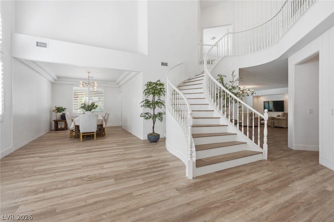 9615 Sedona Hills Court, Las Vegas, NV 89147 A grand spiral staircase welcomes guests into this elegant entry, with rich hardwood flooring flowing into the dining area.