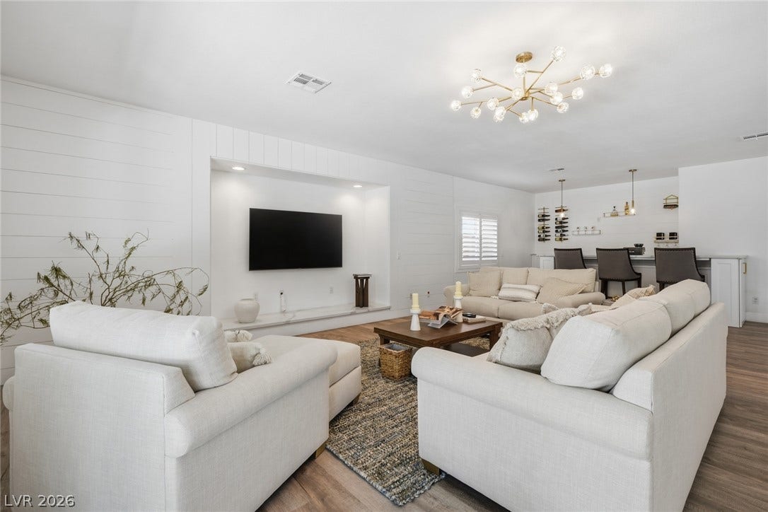 9615 Sedona Hills Court, Las Vegas, NV 89147 Modern elegance defines this inviting living space, featuring wood flooring and a chic wet bar perfect for entertaining.