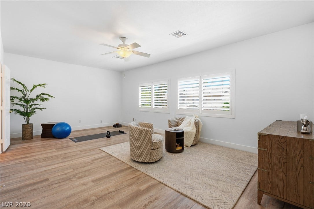 9615 Sedona Hills Court, Las Vegas, NV 89147 Well-lit room with wood flooring and bright windows offers a versatile space for recreation or relaxation.