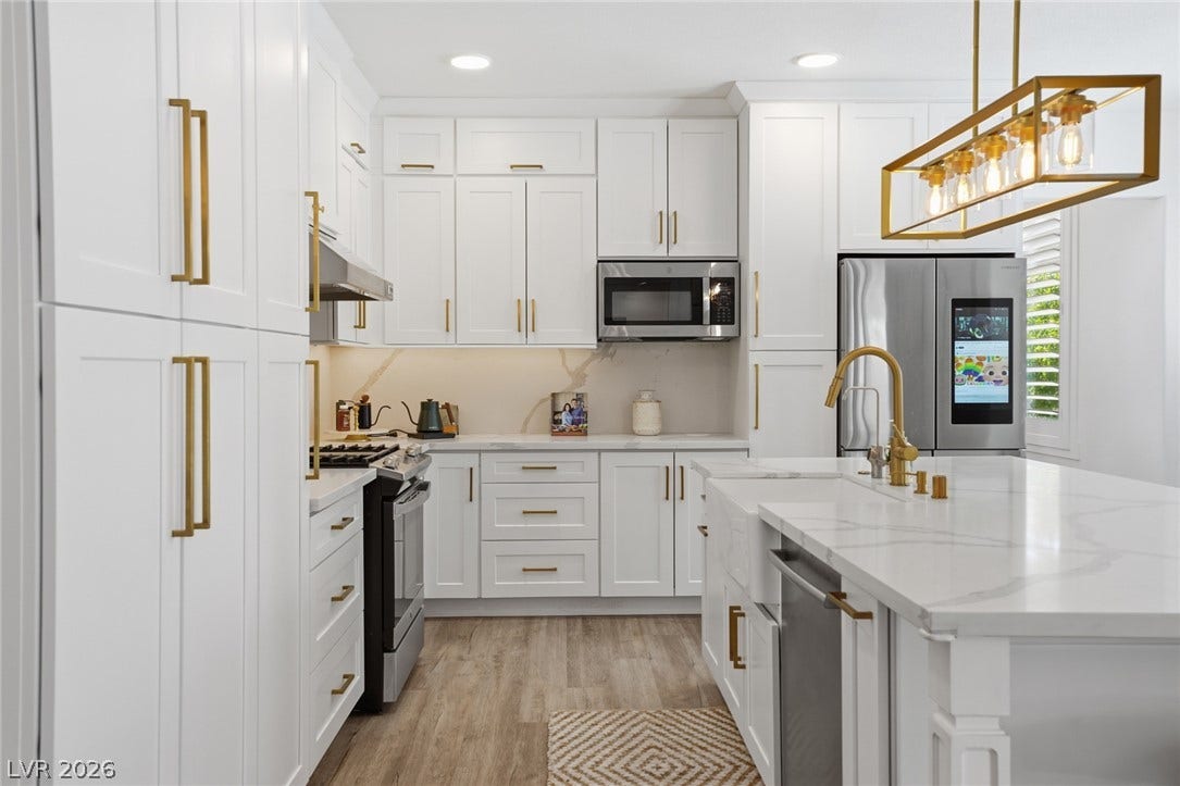 9615 Sedona Hills Court, Las Vegas, NV 89147 A brilliant kitchen featuring white cabinetry and gold hardware offers modern elegance and culinary delight.