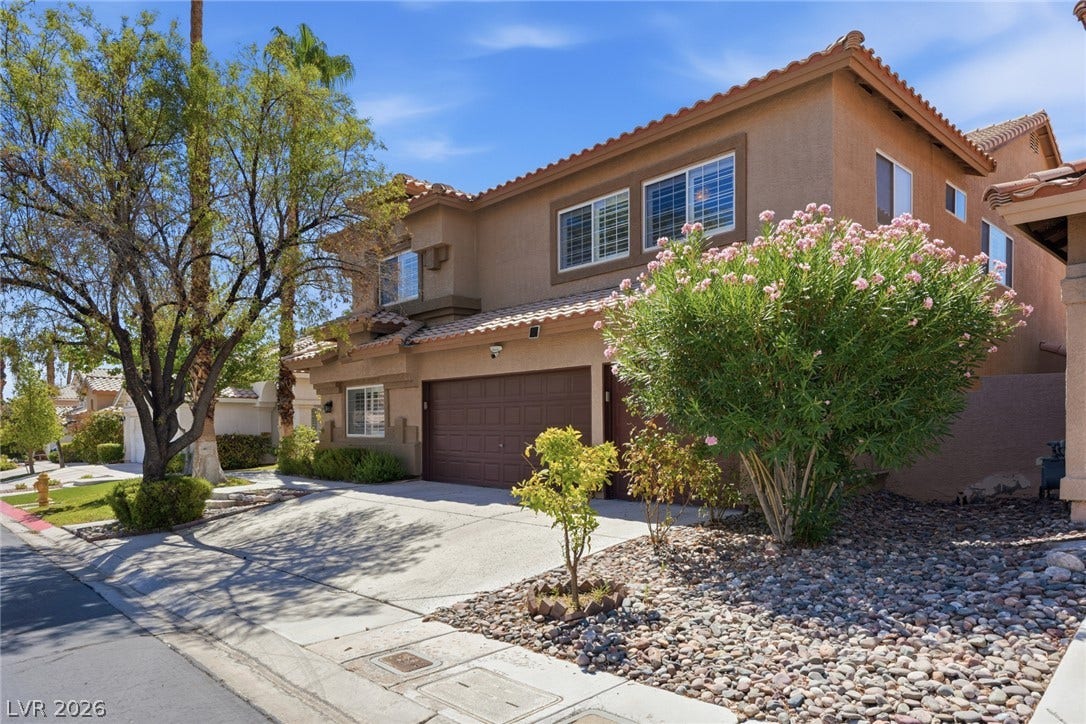9615 Sedona Hills Court, Las Vegas, NV 89147 A terracotta-tiled roof crowns this residence, featuring an attached garage and desert-friendly landscaping.