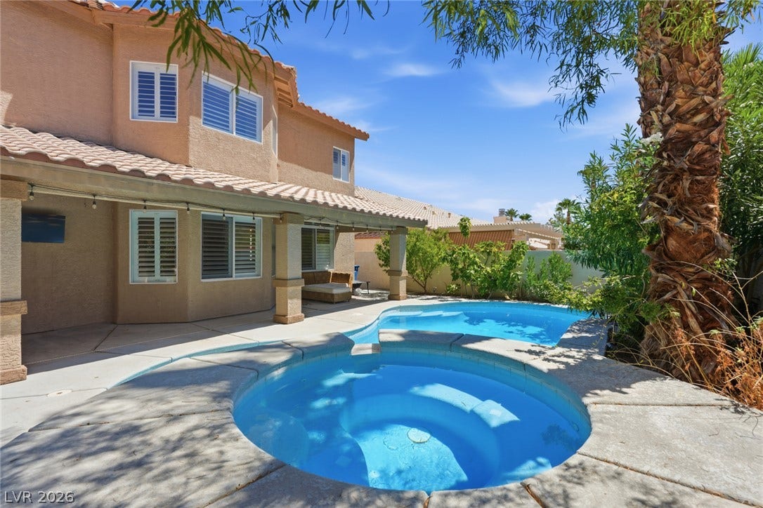 9615 Sedona Hills Court, Las Vegas, NV 89147 An inviting backyard features a sparkling pool and spa, alongside a covered patio for outdoor relaxation.