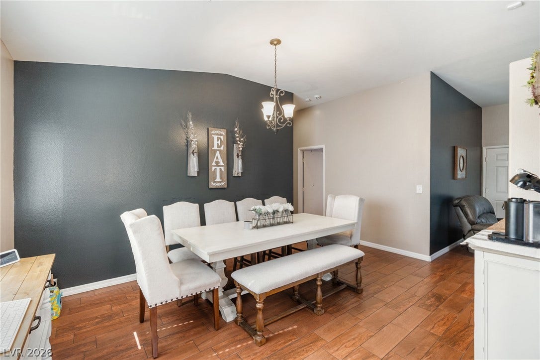A graceful dining area, crowned with a distinctive vaulted ceiling and featuring rich wood flooring.
