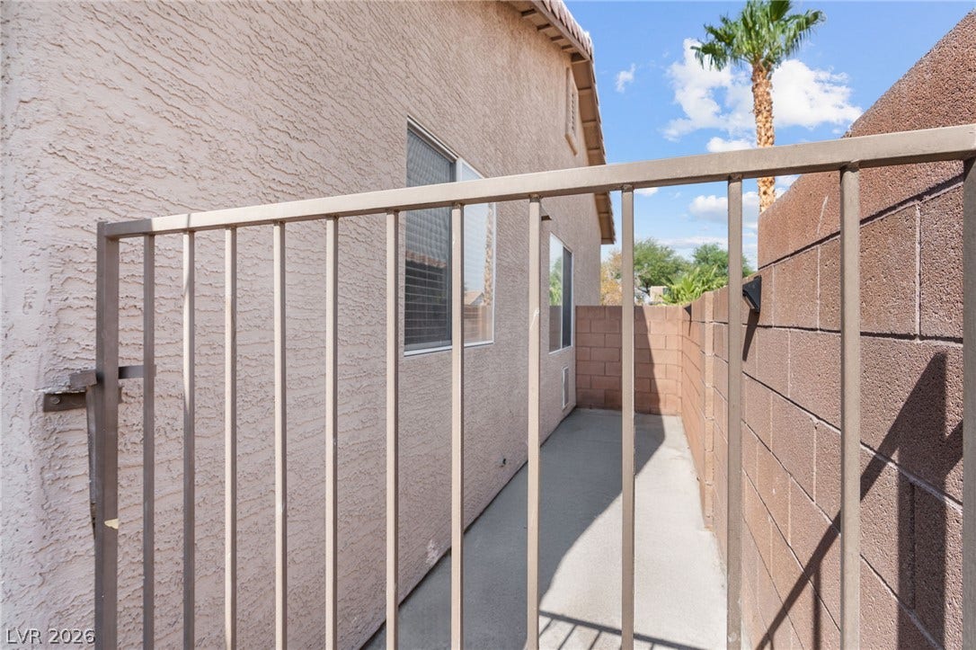 A secured side yard offers a private, accessible outdoor space between the residence and a substantial perimeter wall.