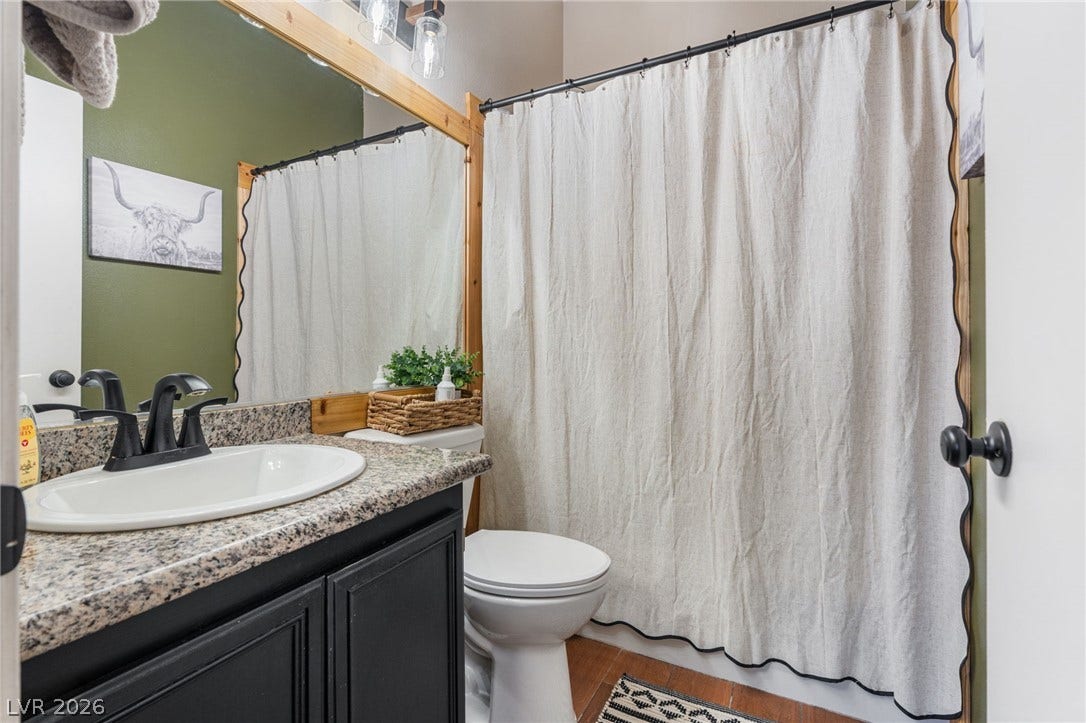 Granite counters and a framed mirror enhance this well-appointed bathroom space.