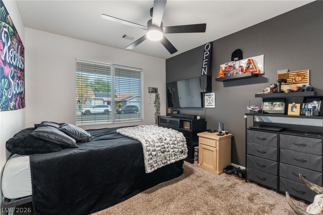 Well-lit sleeping quarters with a ceiling fan offers a comfortable personal retreat.