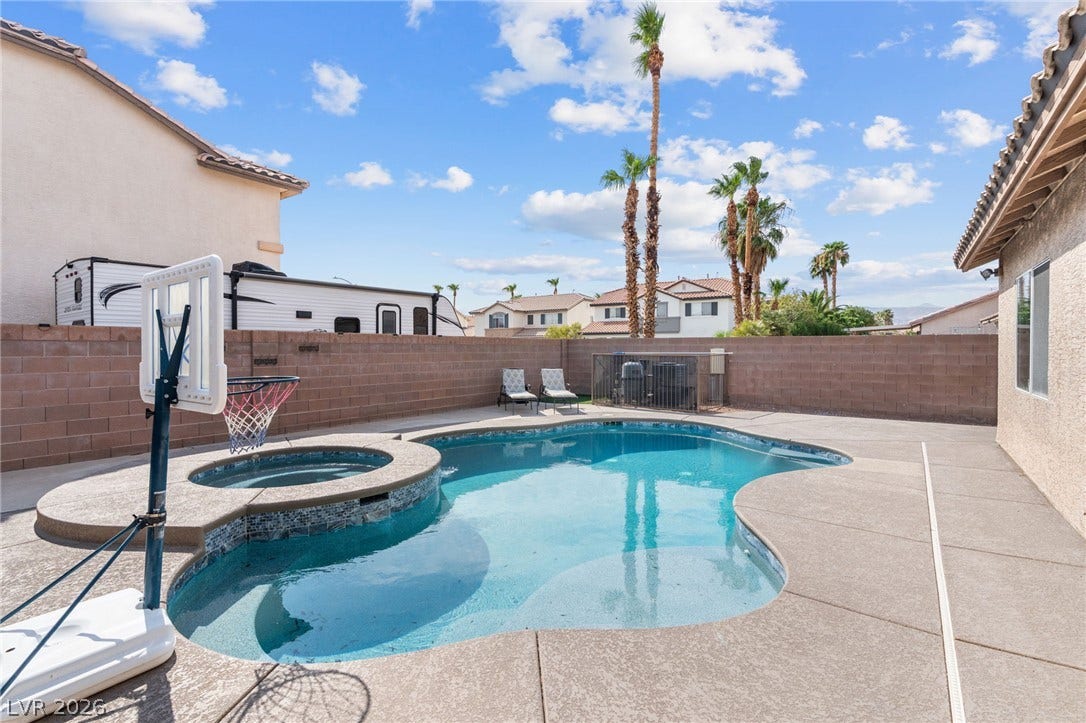 An inviting backyard oasis awaits with a sparkling pool and spa, perfect for relaxation or recreation.