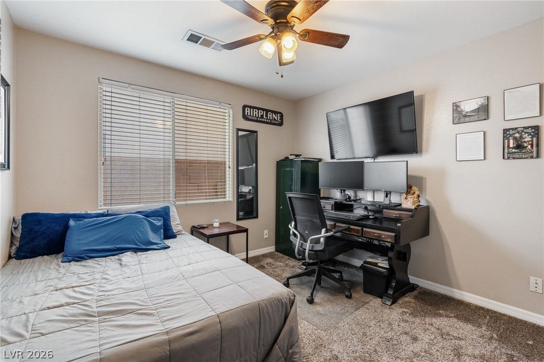 Well-lit sleeping quarters with a dedicated work area and plush carpeting.