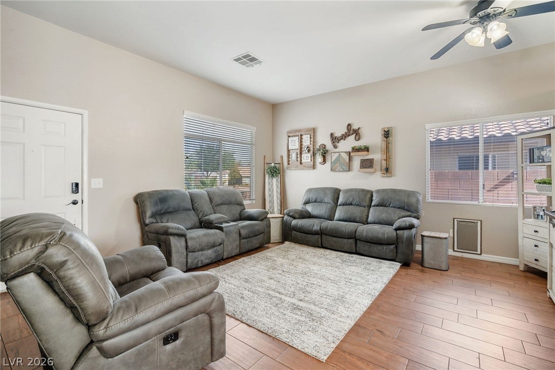 A comfortable living space featuring rich wood flooring and abundant natural light.