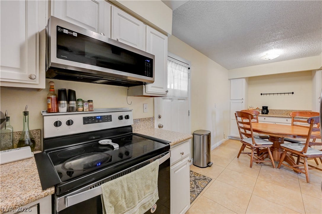 263 E Van Wagenen Street, Henderson, NV 89015 Tiled flooring and granite-look countertops anchor this functional kitchen and dining space.