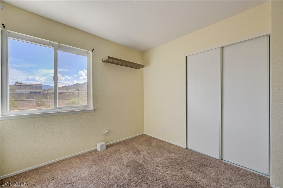 263 E Van Wagenen Street, Henderson, NV 89015 Natural light fills this cozy bedroom featuring soft carpeting and a sliding closet door.