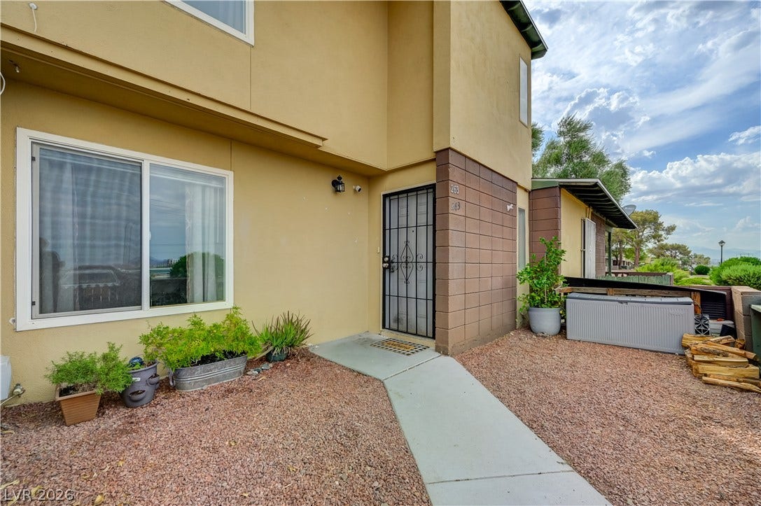 263 E Van Wagenen Street, Henderson, NV 89015 A concrete walkway leads to the private gated entrance of this multi-level home.
