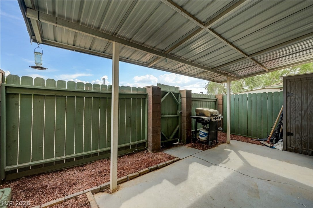 263 E Van Wagenen Street, Henderson, NV 89015 A sheltered concrete patio opens to a fully enclosed backyard bordered by high wood fencing.