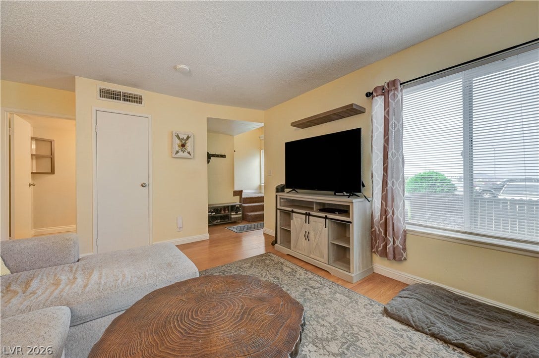 263 E Van Wagenen Street, Henderson, NV 89015 Warm wood flooring and an expansive window create a welcoming atmosphere in this comfortable living space.