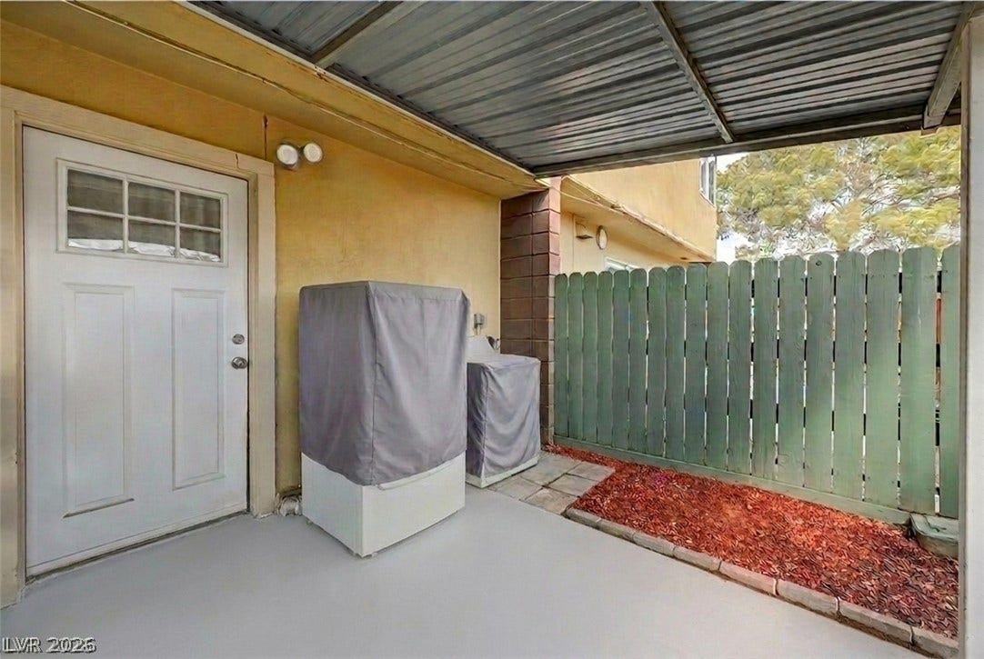 263 E Van Wagenen Street, Henderson, NV 89015 A sheltered patio area features concrete flooring and is bordered by a private wooden fence.