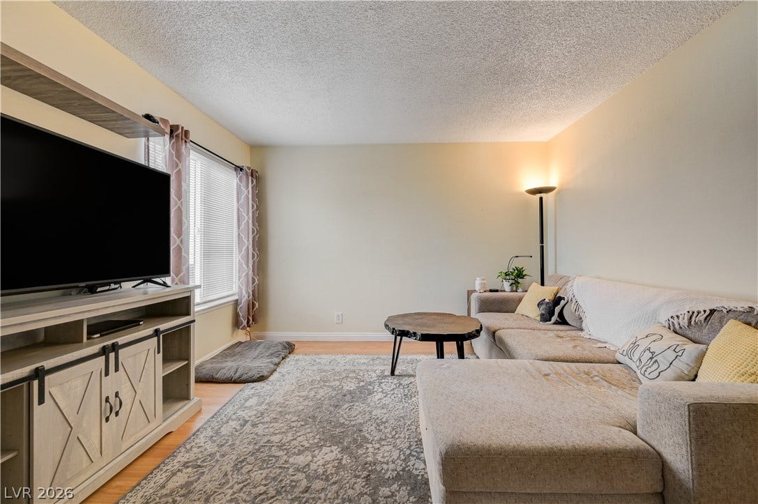 263 E Van Wagenen Street, Henderson, NV 89015 A spacious living area features smooth wood flooring and wide windows welcoming natural light.