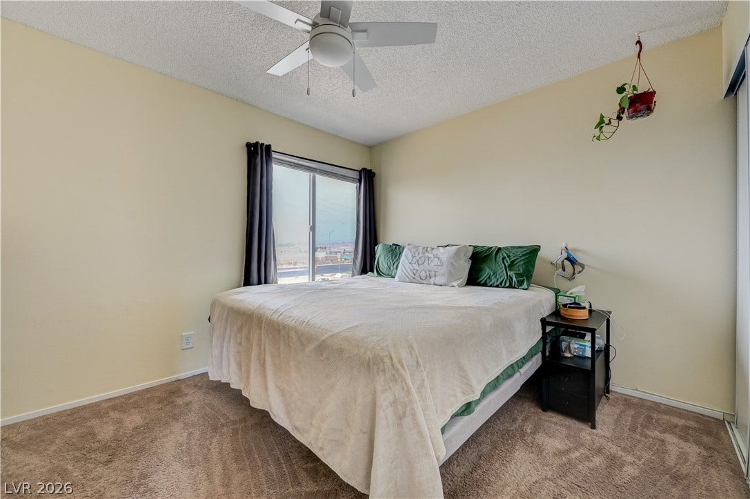 263 E Van Wagenen Street, Henderson, NV 89015 Natural light streams through sliding glass doors onto plush carpeting in this bedroom.