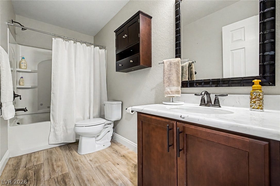 A well-appointed bathroom offers a clean vanity with ample storage and a classic shower-tub combination.