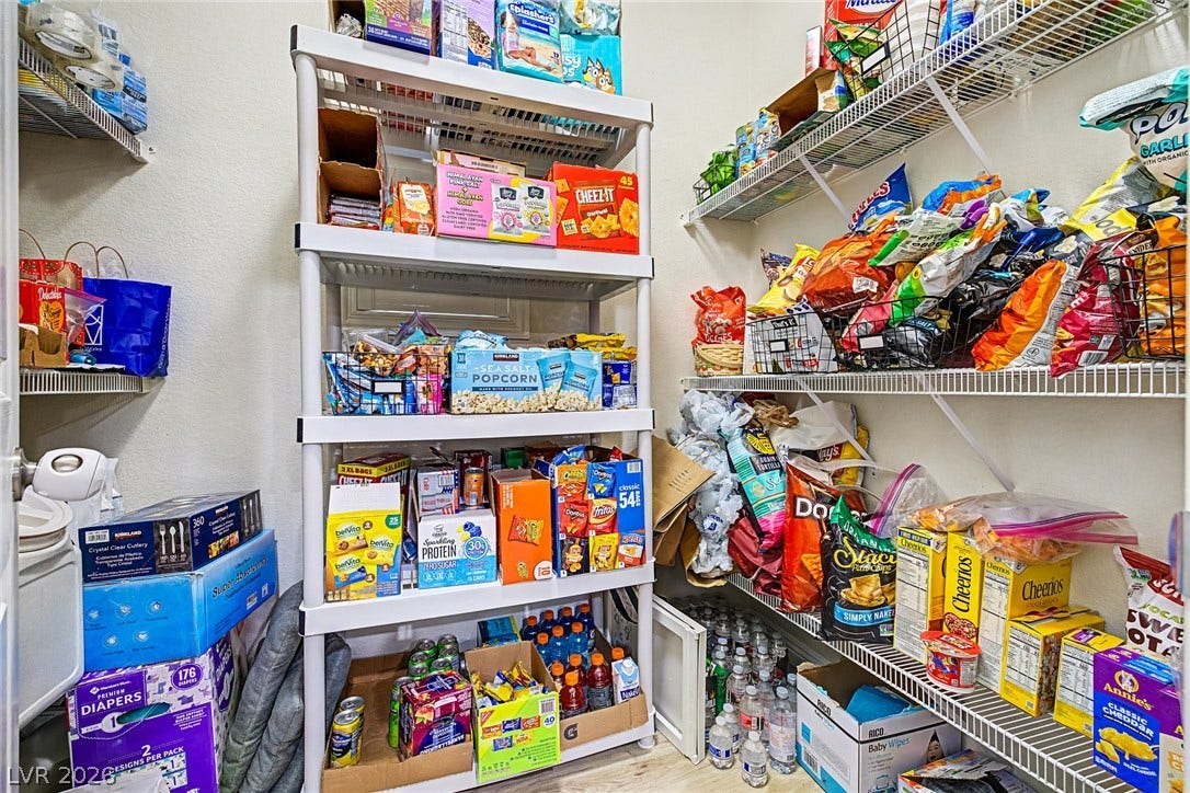 Organized wire shelving and a multi-tiered rack provide ample storage in this well-appointed pantry.