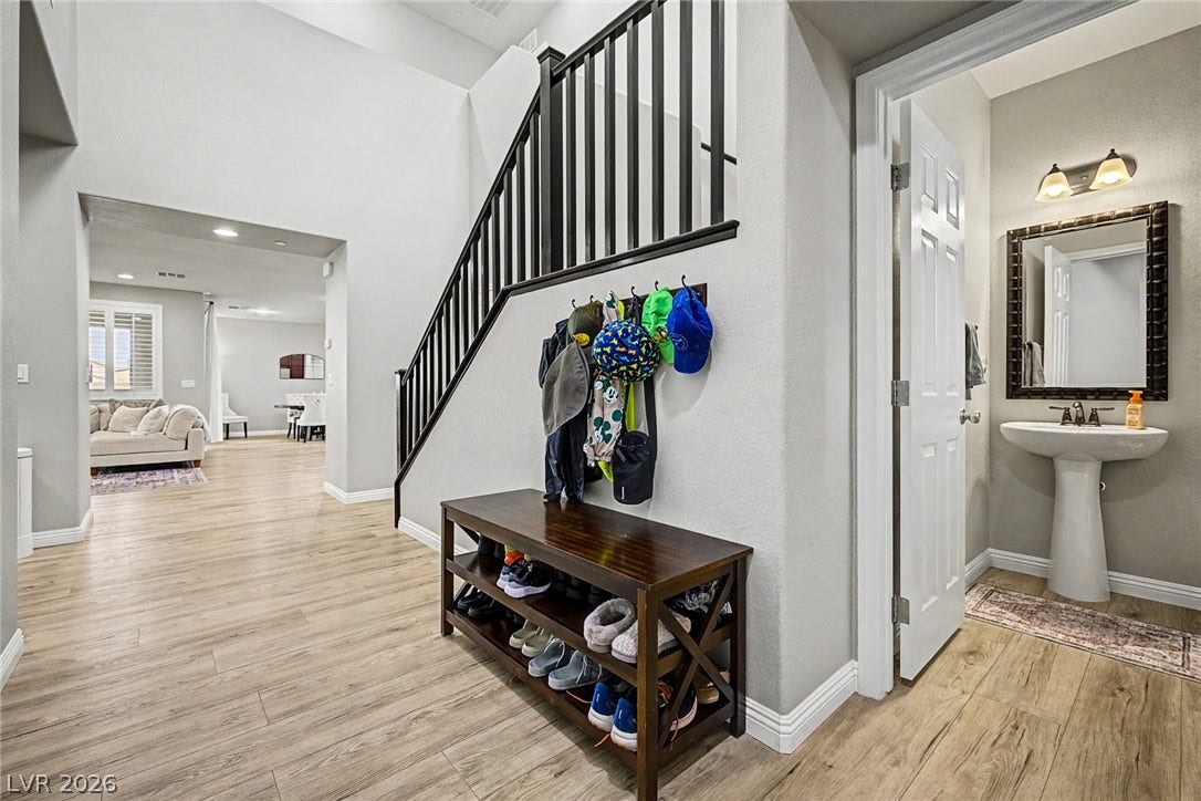 A welcoming entryway introduces high ceilings and durable flooring, with a convenient powder room nearby.
