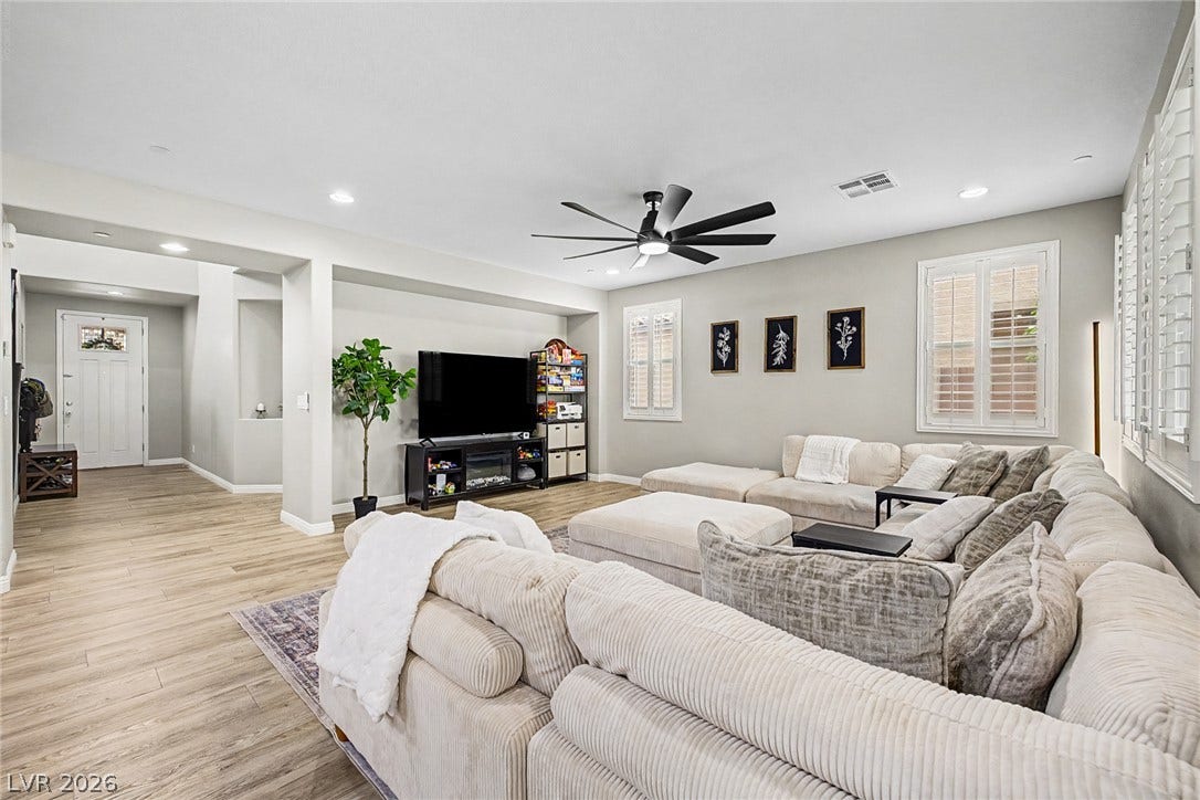 An inviting great room with ample natural light, featuring wood flooring and modern recessed lighting.