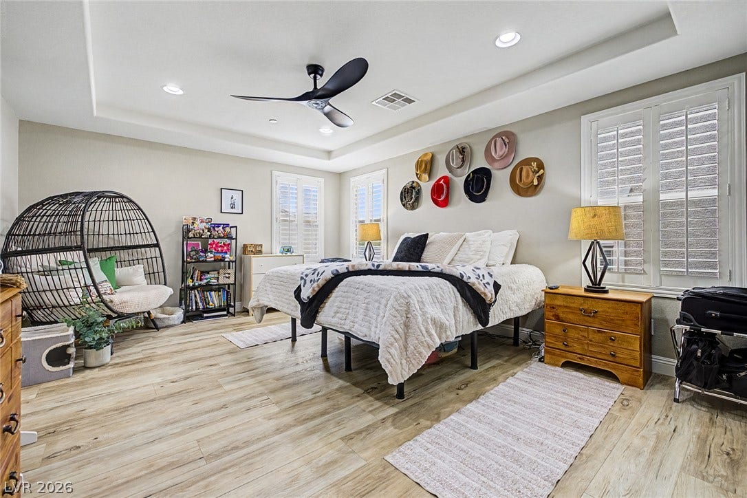 Recessed lighting and a modern ceiling fan illuminate this inviting bedroom, featuring light-toned flooring.