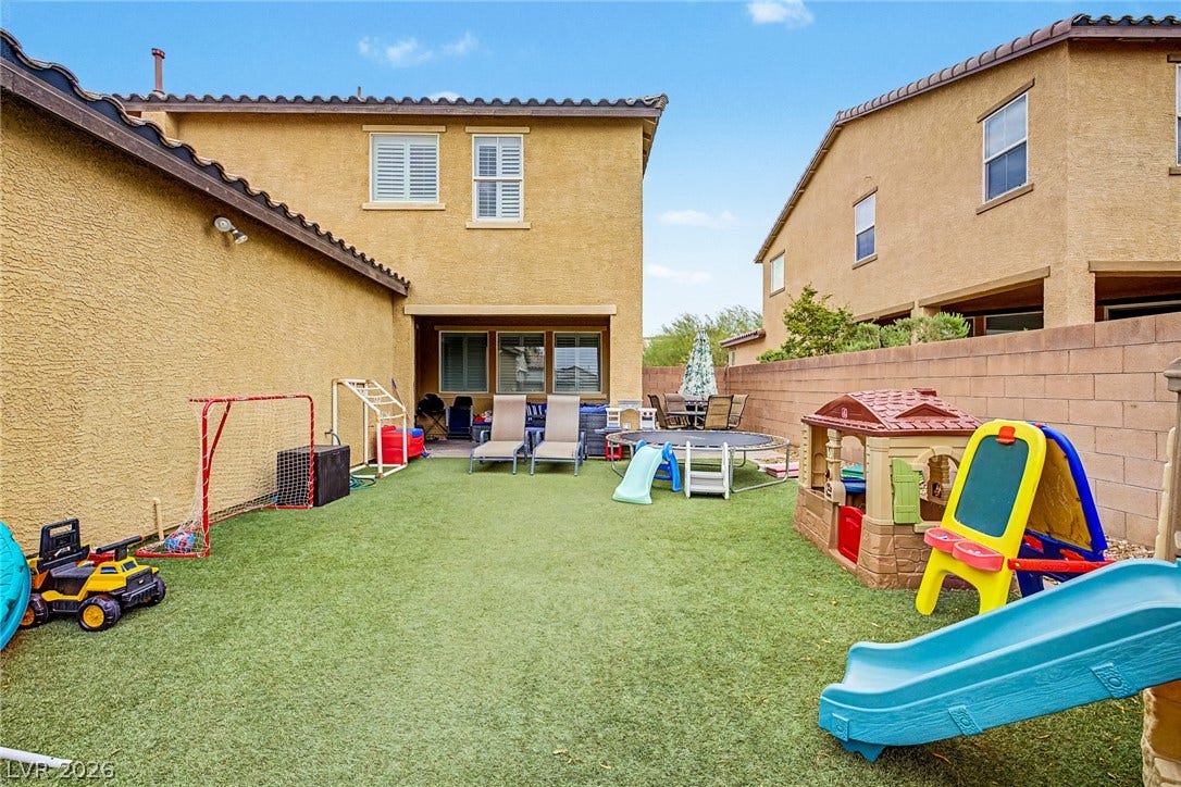 A private, fenced backyard offers a perfect recreational area for both leisure and play.