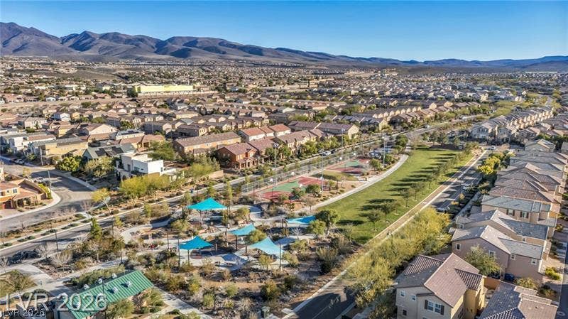 Expansive community parklands and athletic courts rest against a backdrop of desert mountains.