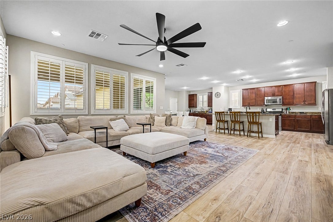An open-concept great room offers seamless flow between living and kitchen spaces, illuminated by recessed lighting and natural light.