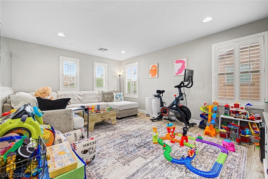 Well-lit living area features multiple windows, recessed lighting, and durable wood flooring.