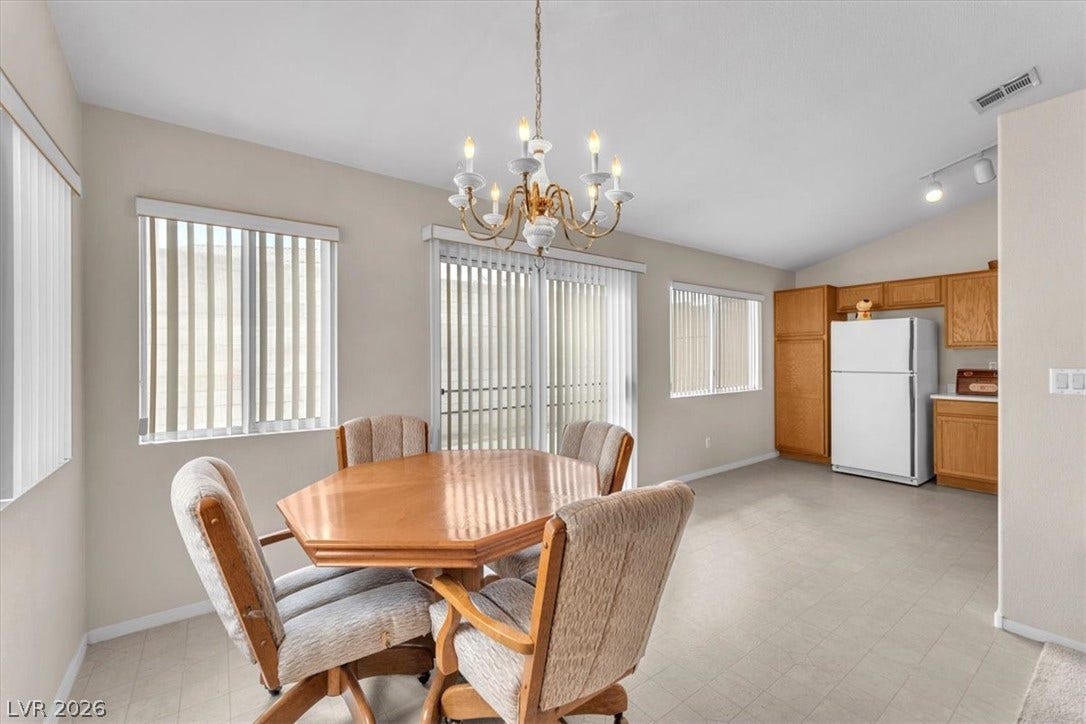 1163 Teal Point Drive, Henderson, NV 89074 Dining room with visible vents, baseboards, vaulted ceiling, light floors, and an inviting chandelier