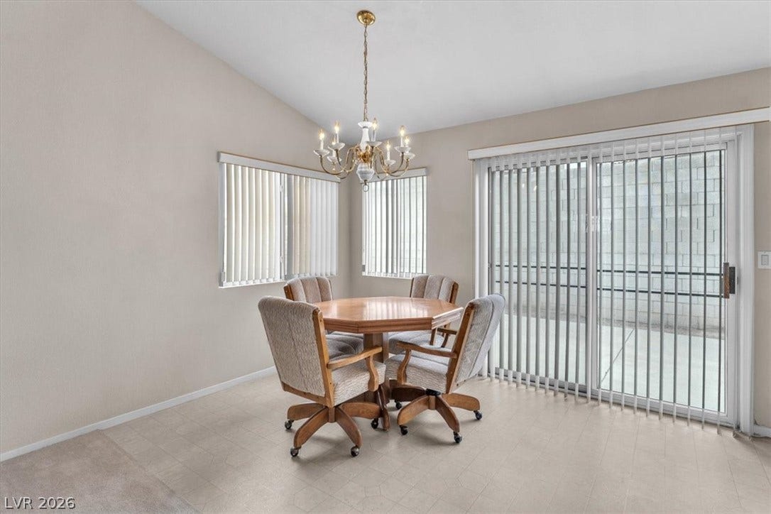 1163 Teal Point Drive, Henderson, NV 89074 Dining room featuring baseboards, vaulted ceiling, a notable chandelier, and tile patterned floors