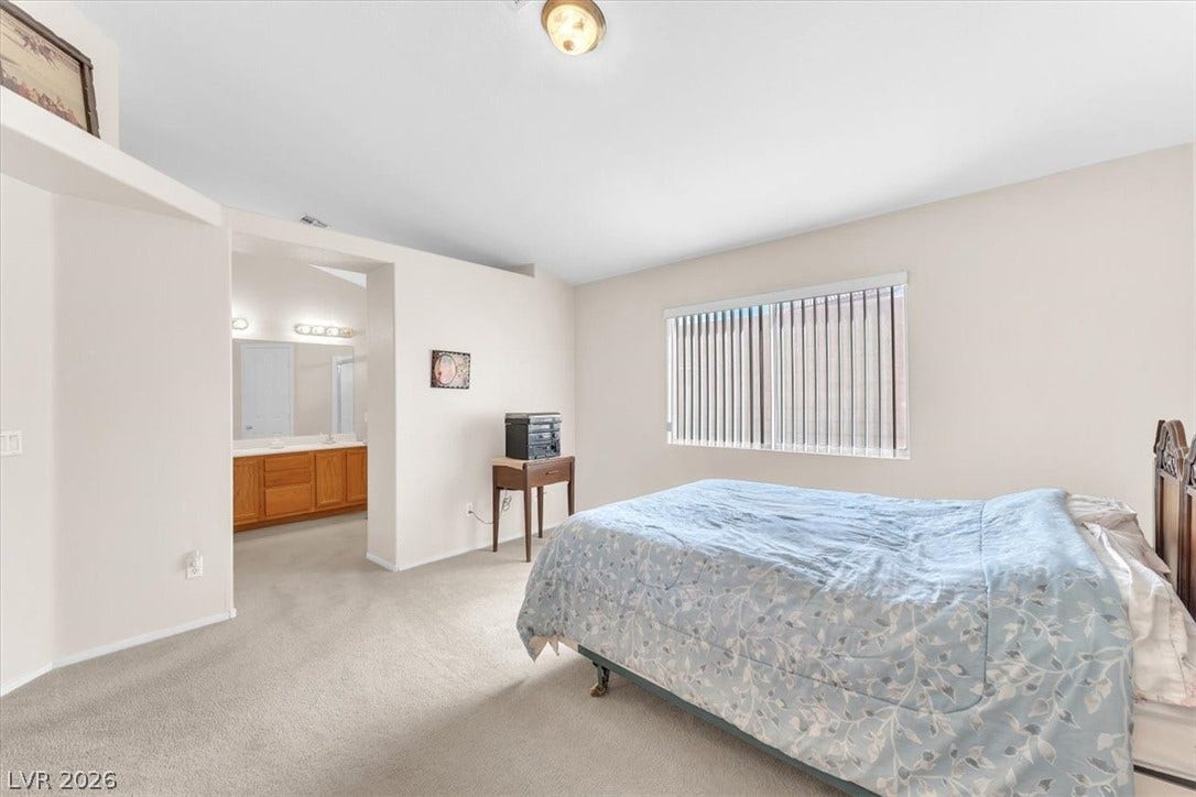 1163 Teal Point Drive, Henderson, NV 89074 Bedroom with light carpet, ensuite bath, and baseboards